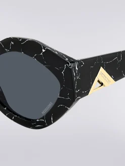 Oval-shaped sunglasses with metal logo application